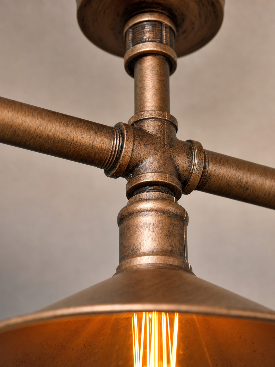 Close-up detail of the Limehouse ceiling light showing brushed copper pipe joints and patina