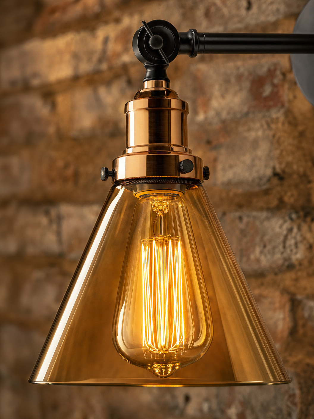 Close-up detail of the Shoreditch wall sconce showing amber glass cone shade and copper socket collar