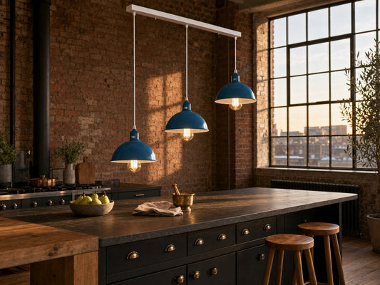 Shoreditch 3-light industrial dome bar pendant in petrol blue, suspended over a soapstone kitchen island in a London warehouse-conversion loft kitchen with exposed brick and Crittall windows